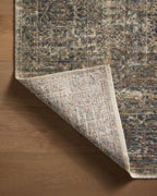 Vintage-style distressed rug with muted grey, tan, and rust tones throughout