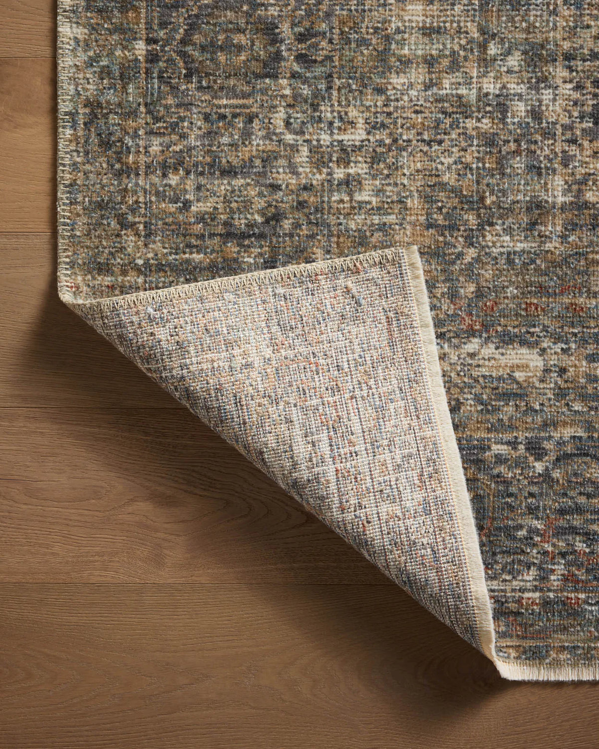Vintage-style distressed rug with muted grey, tan, and rust tones throughout
