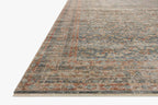 Vintage-style rug with intricate geometric patterns in blue, rust and cream tones