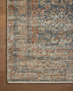 Vintage-style rug with intricate geometric patterns in blue, rust and cream tones