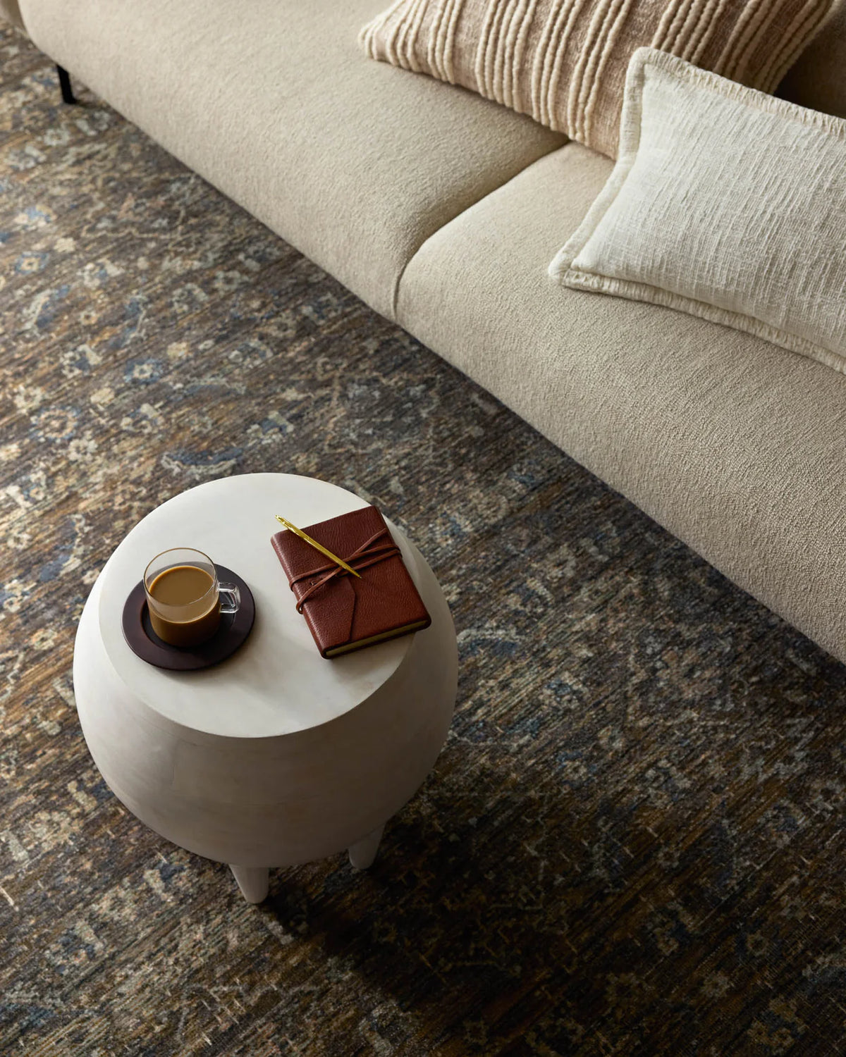Vintage-style area rug with brown and blue tones, intricate floral pattern and distressed finish