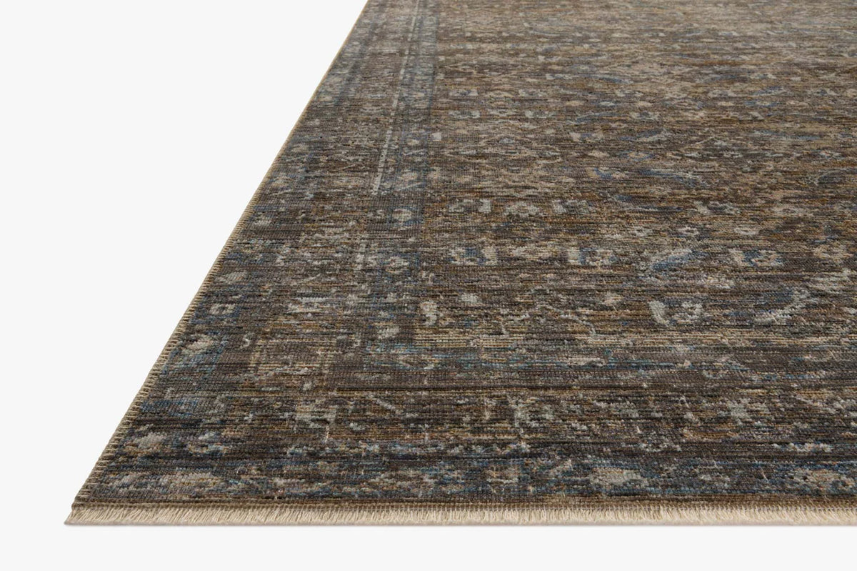 Vintage-style area rug with brown and blue tones, intricate floral pattern and distressed finish