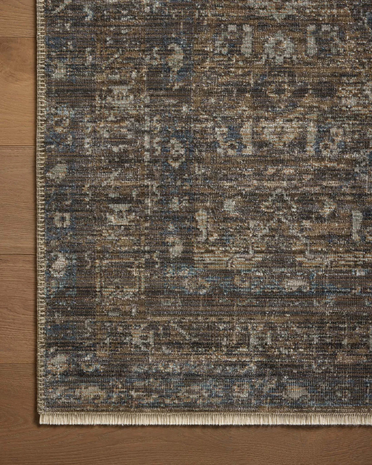 Vintage-style area rug with brown and blue tones, intricate floral pattern and distressed finish