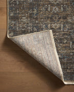 Vintage-style area rug with brown and blue tones, intricate floral pattern and distressed finish