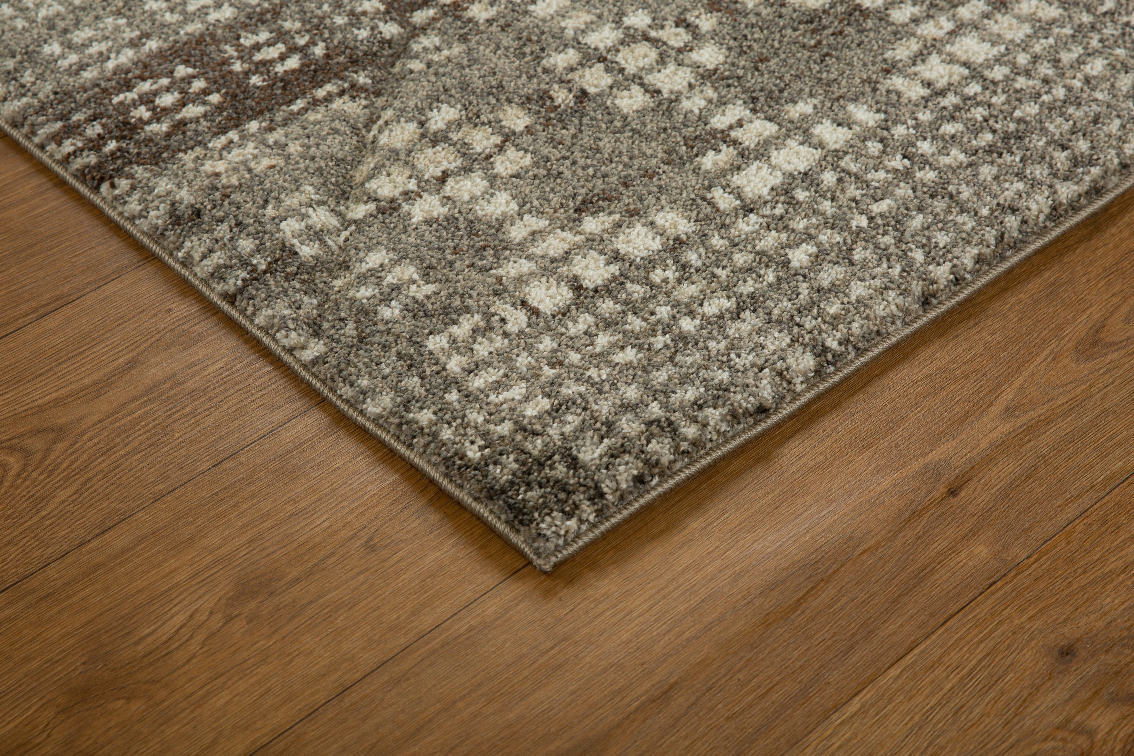 Brown and cream geometric patterned rug with textured weave design