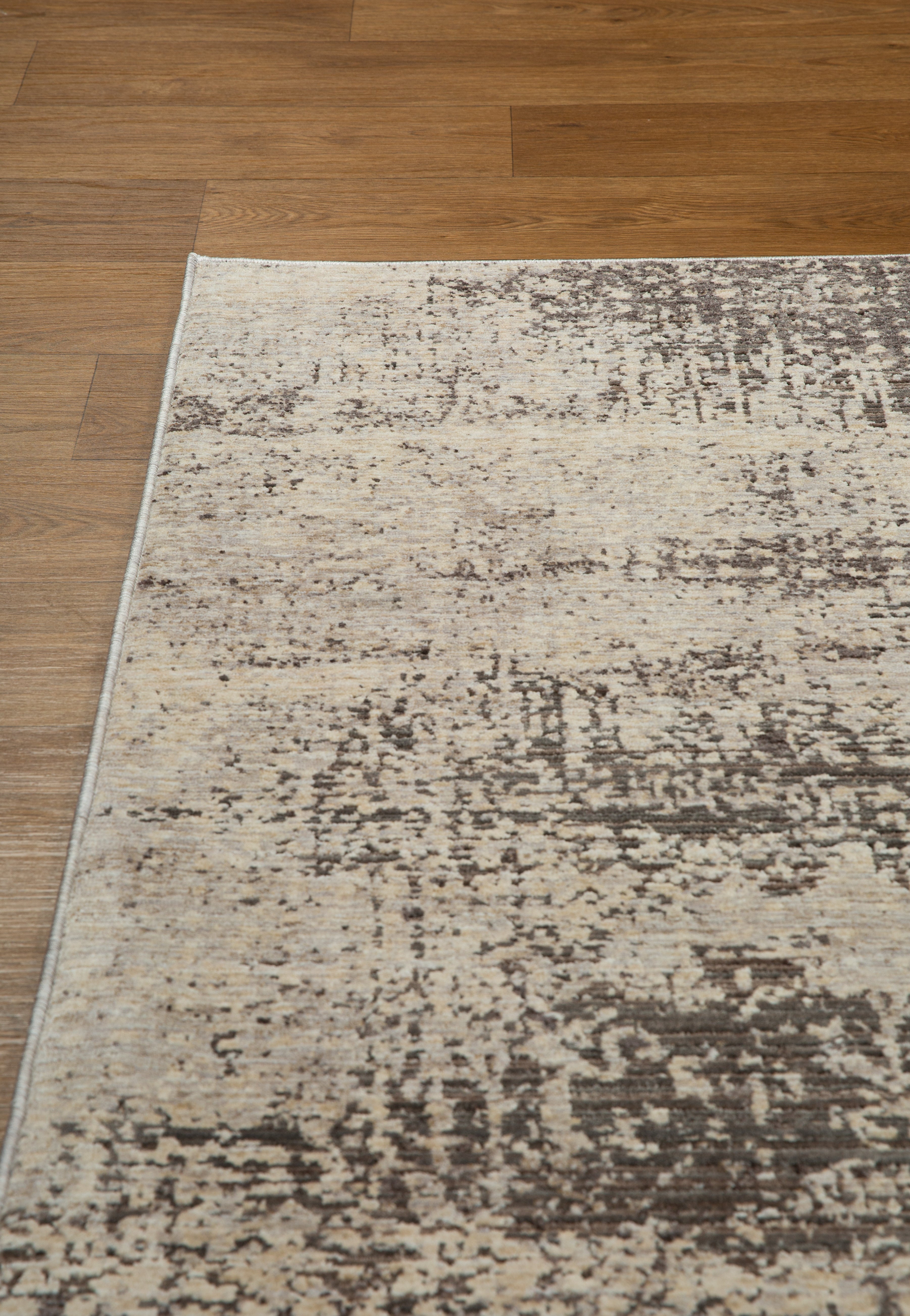 Modern abstract distressed rug with cream and charcoal gray textured pattern