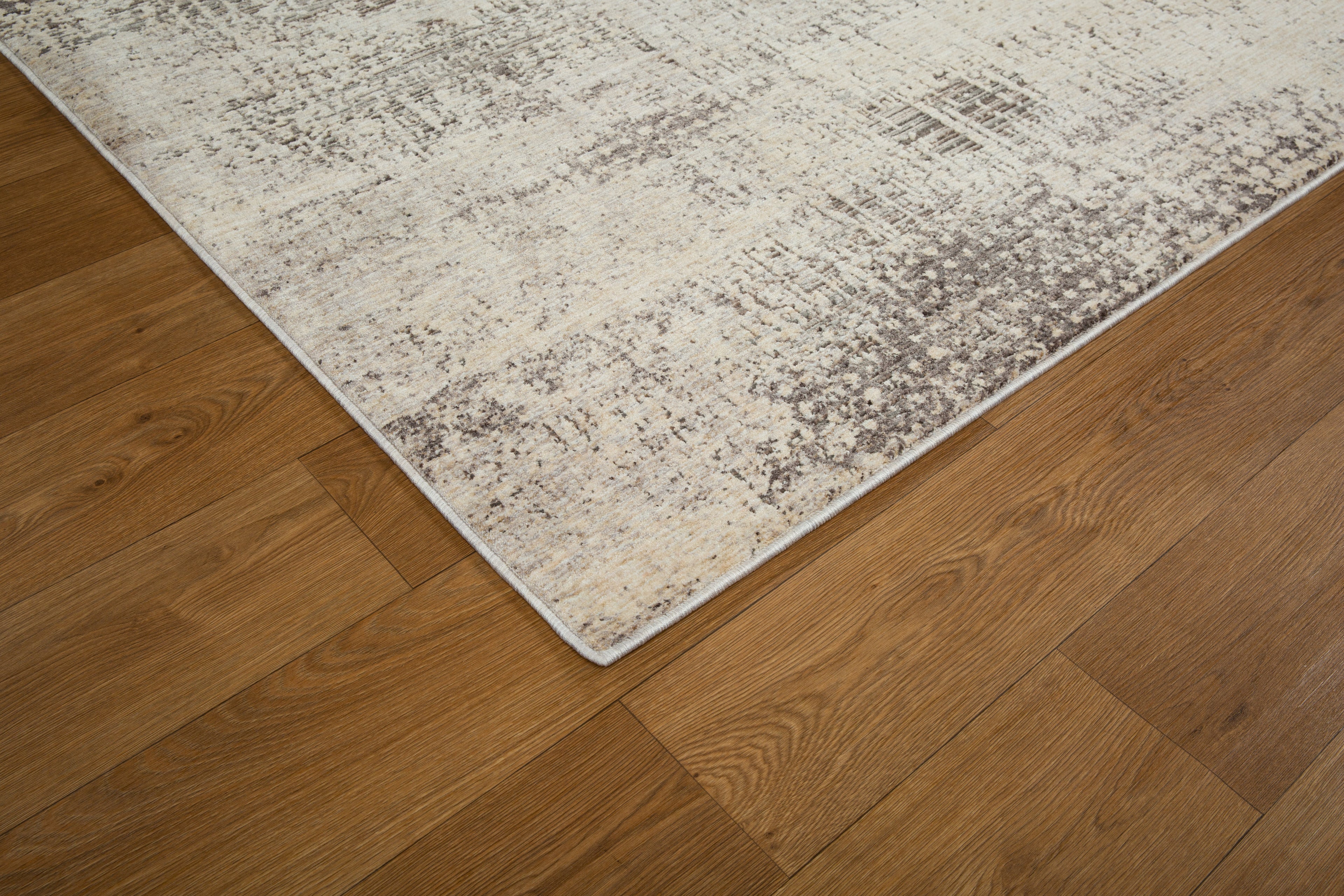 Modern abstract distressed rug with cream and charcoal gray textured pattern