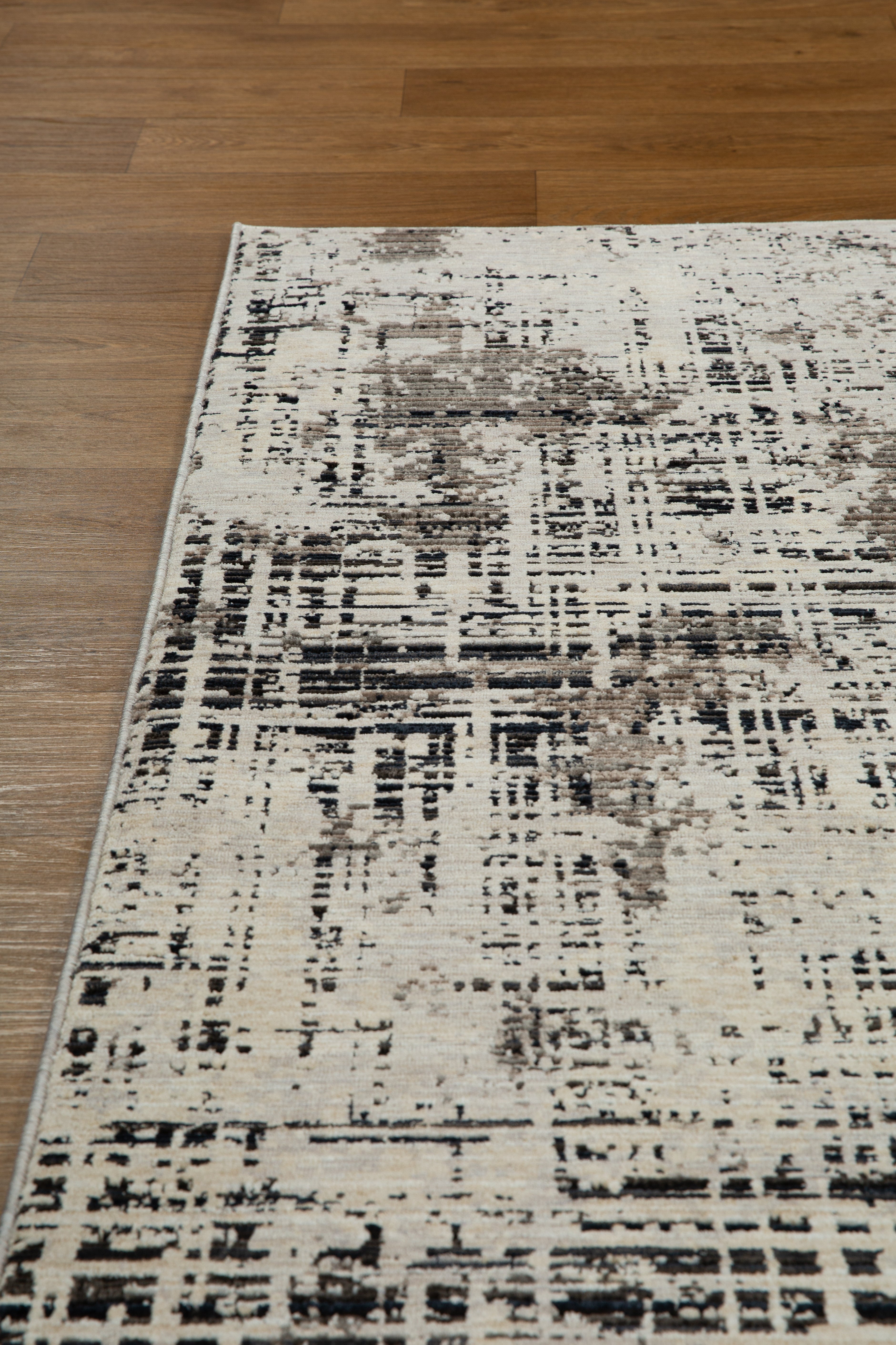 Modern distressed rug with abstract geometric pattern in cream and charcoal gray tones