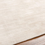 Soft beige wool rug with subtle woven texture and natural fibers