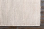 Soft beige wool rug with subtle woven texture and natural fibers