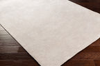 Soft beige wool rug with subtle woven texture and natural fibers