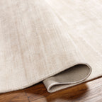 Soft beige wool rug with subtle woven texture and natural fibers
