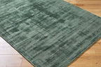 Sage green distressed rug with textured, mottled surface and worn vintage appearance