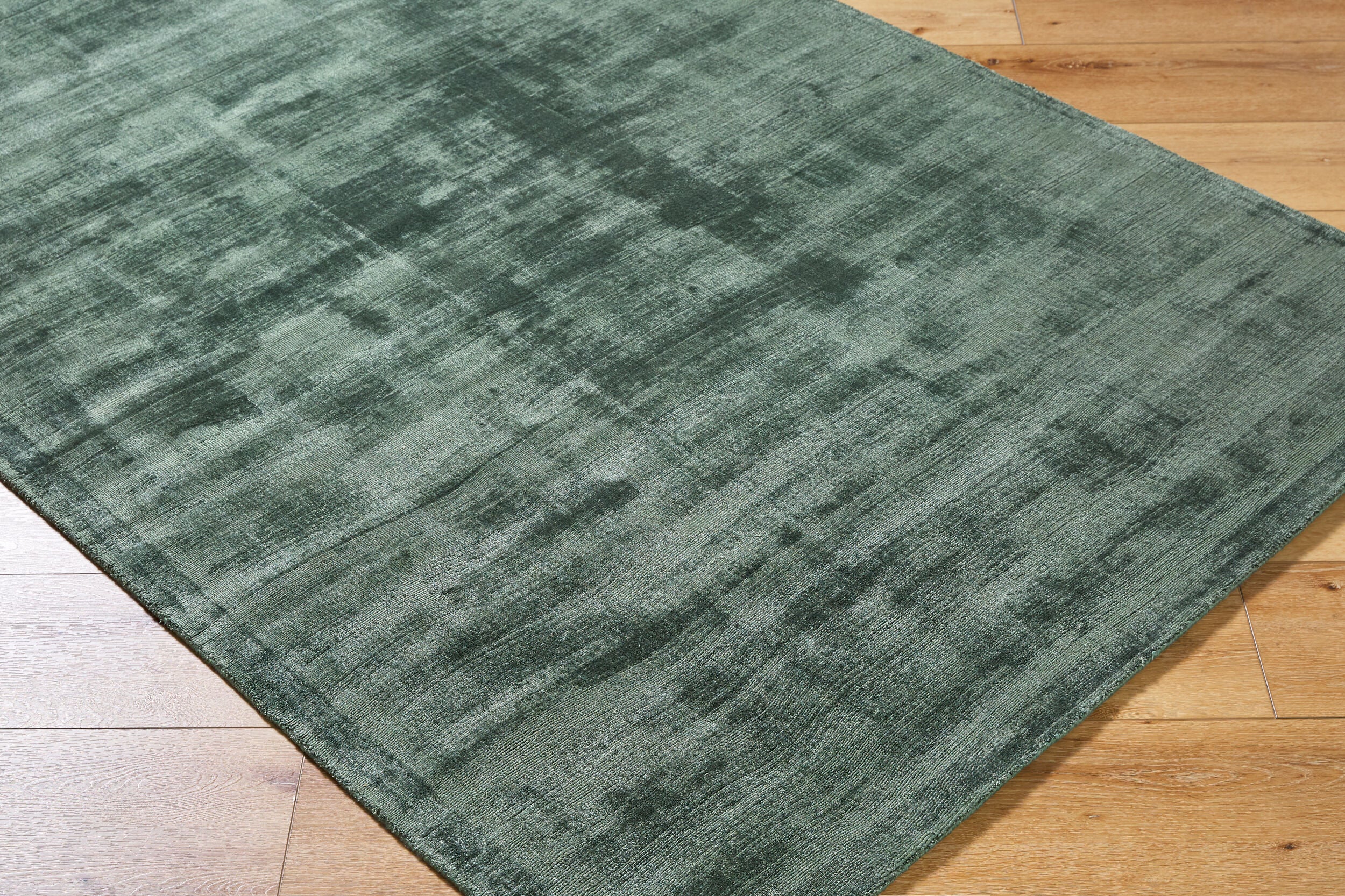 Sage green distressed rug with textured, mottled surface and worn vintage appearance