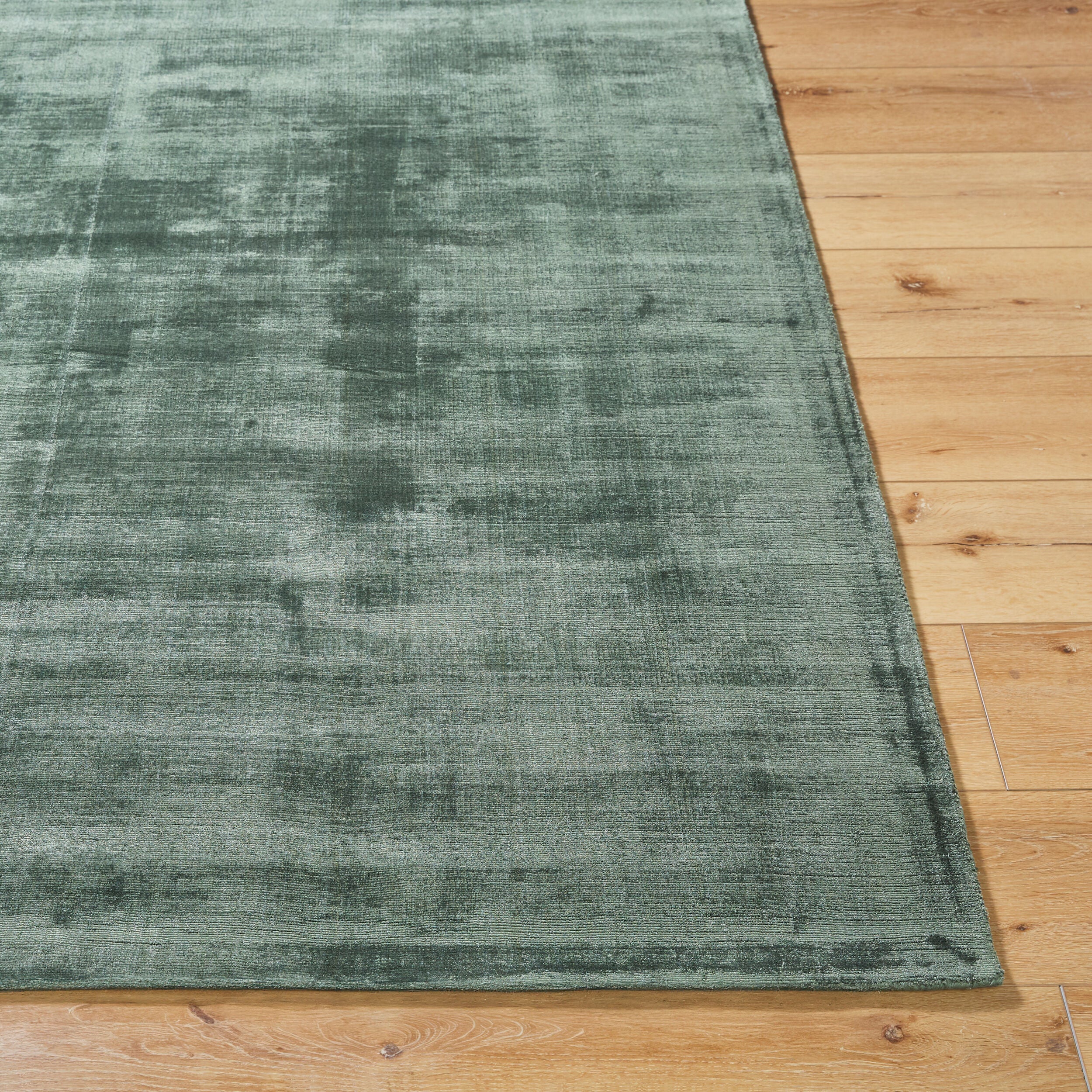 Sage green distressed rug with textured, mottled surface and worn vintage appearance