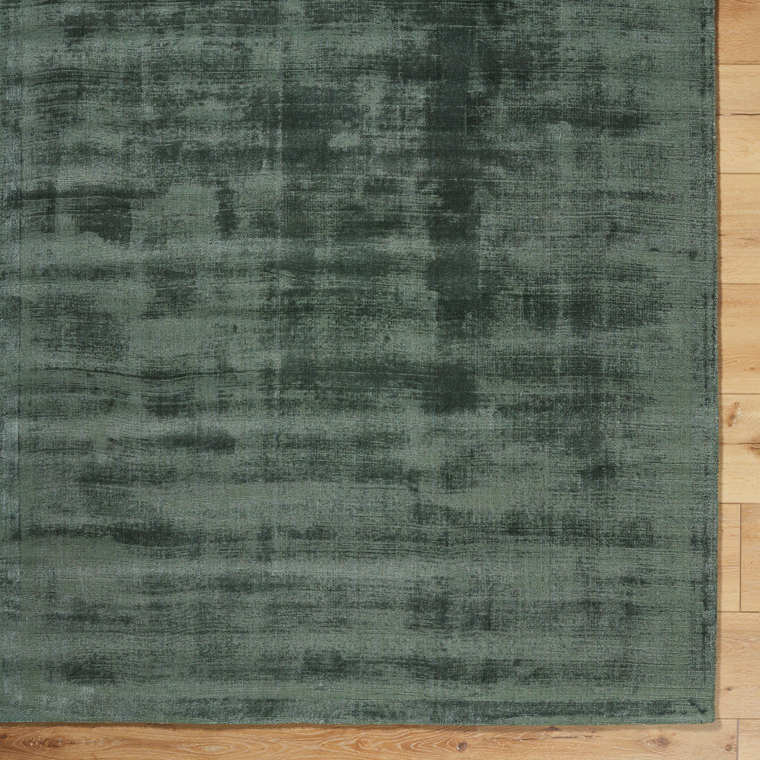 Sage green distressed rug with textured, mottled surface and worn vintage appearance