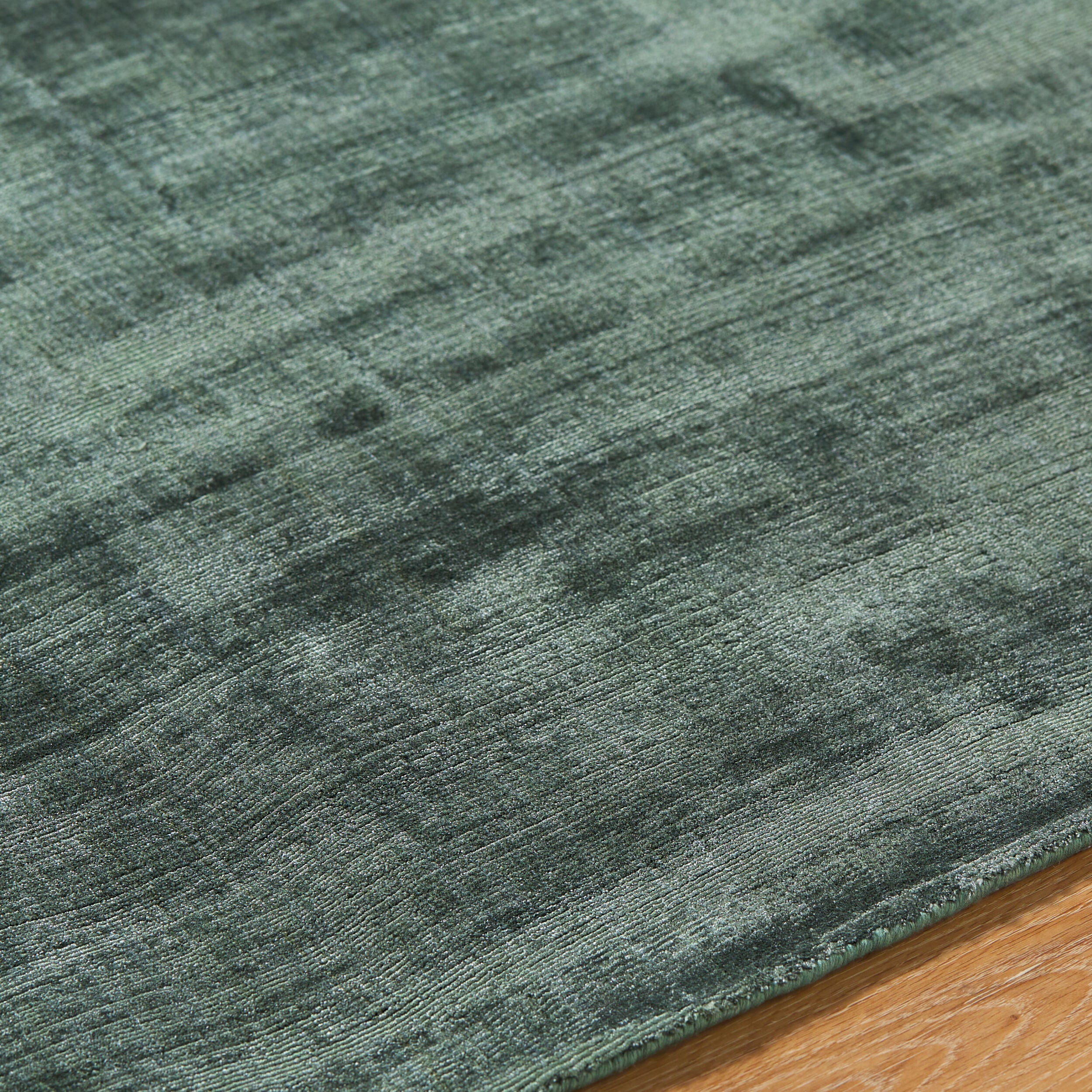 Sage green distressed rug with textured, mottled surface and worn vintage appearance