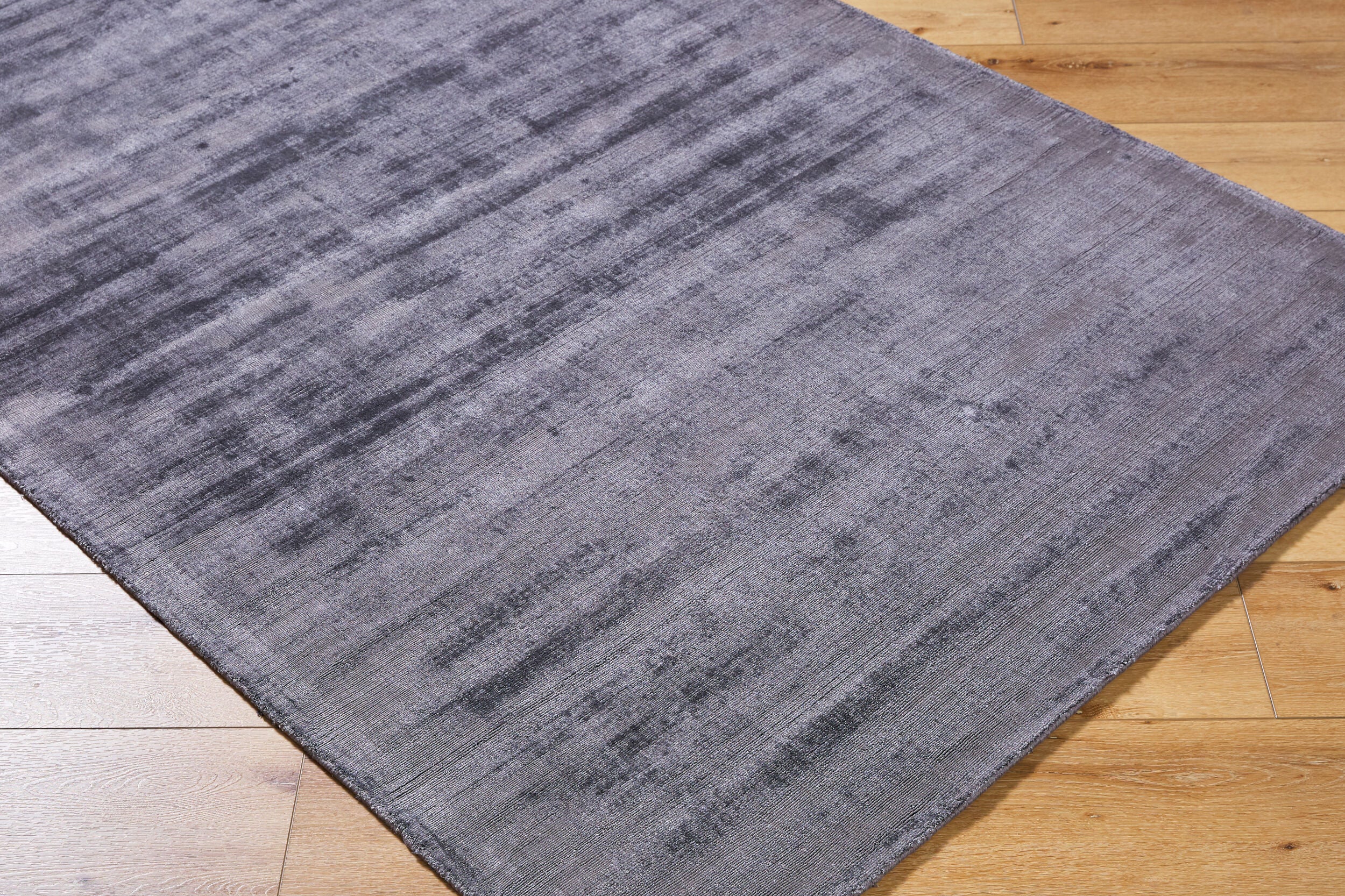 Grey distressed texture rug with subtle worn pattern and matte finish