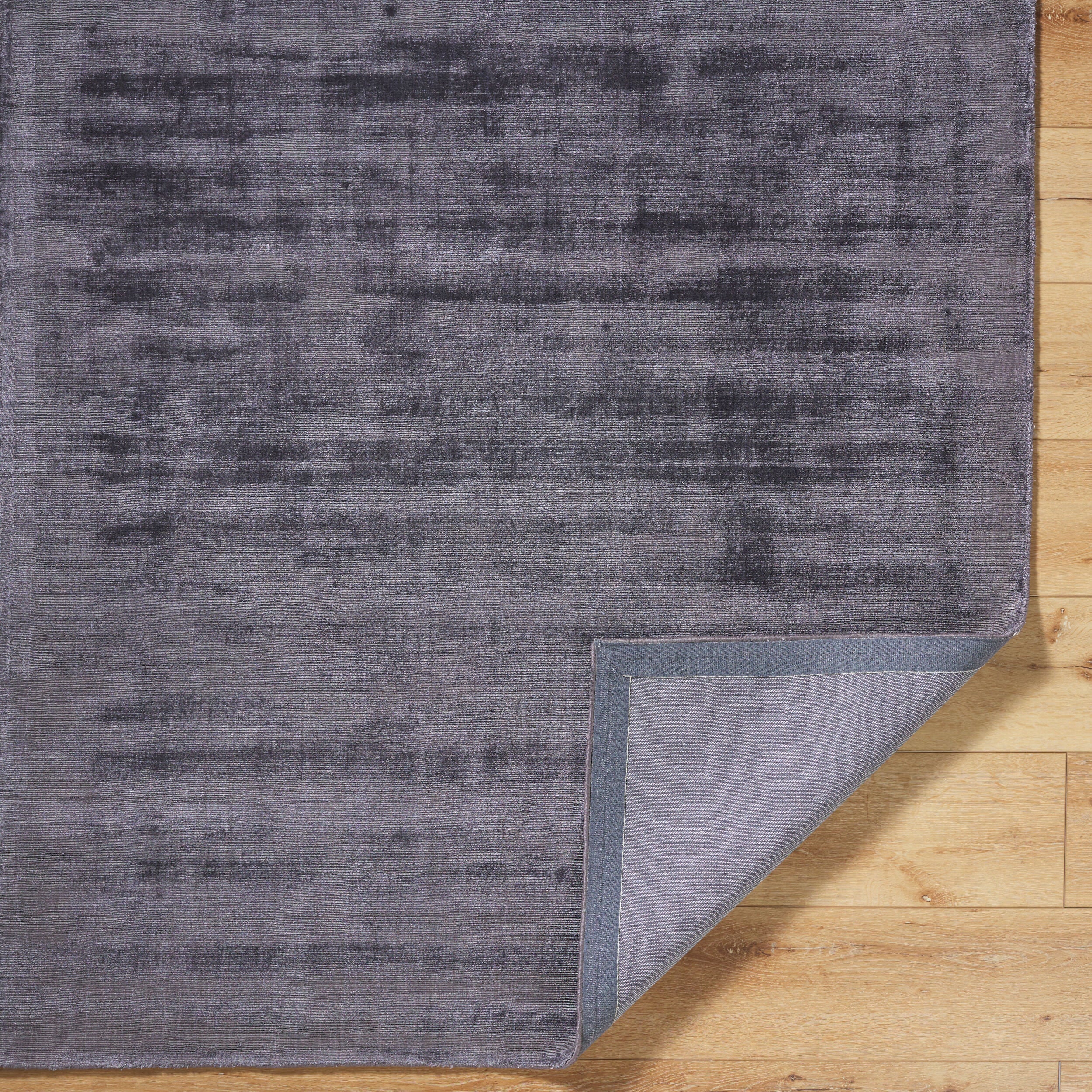 Grey distressed texture rug with subtle worn pattern and matte finish