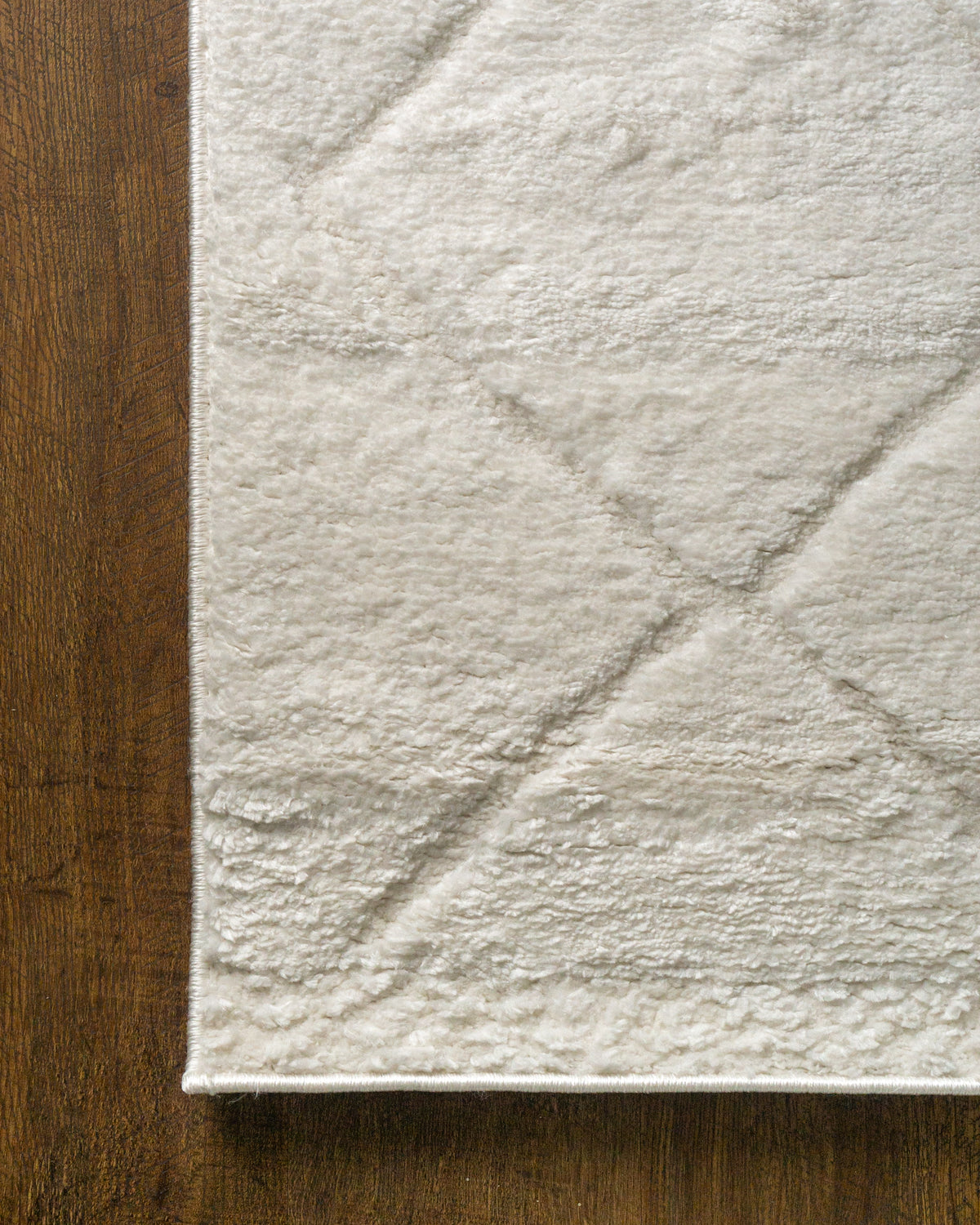 Cream quilted diamond pattern wool area rug with subtle texture
