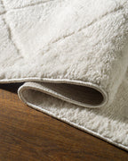 Cream quilted diamond pattern wool area rug with subtle texture