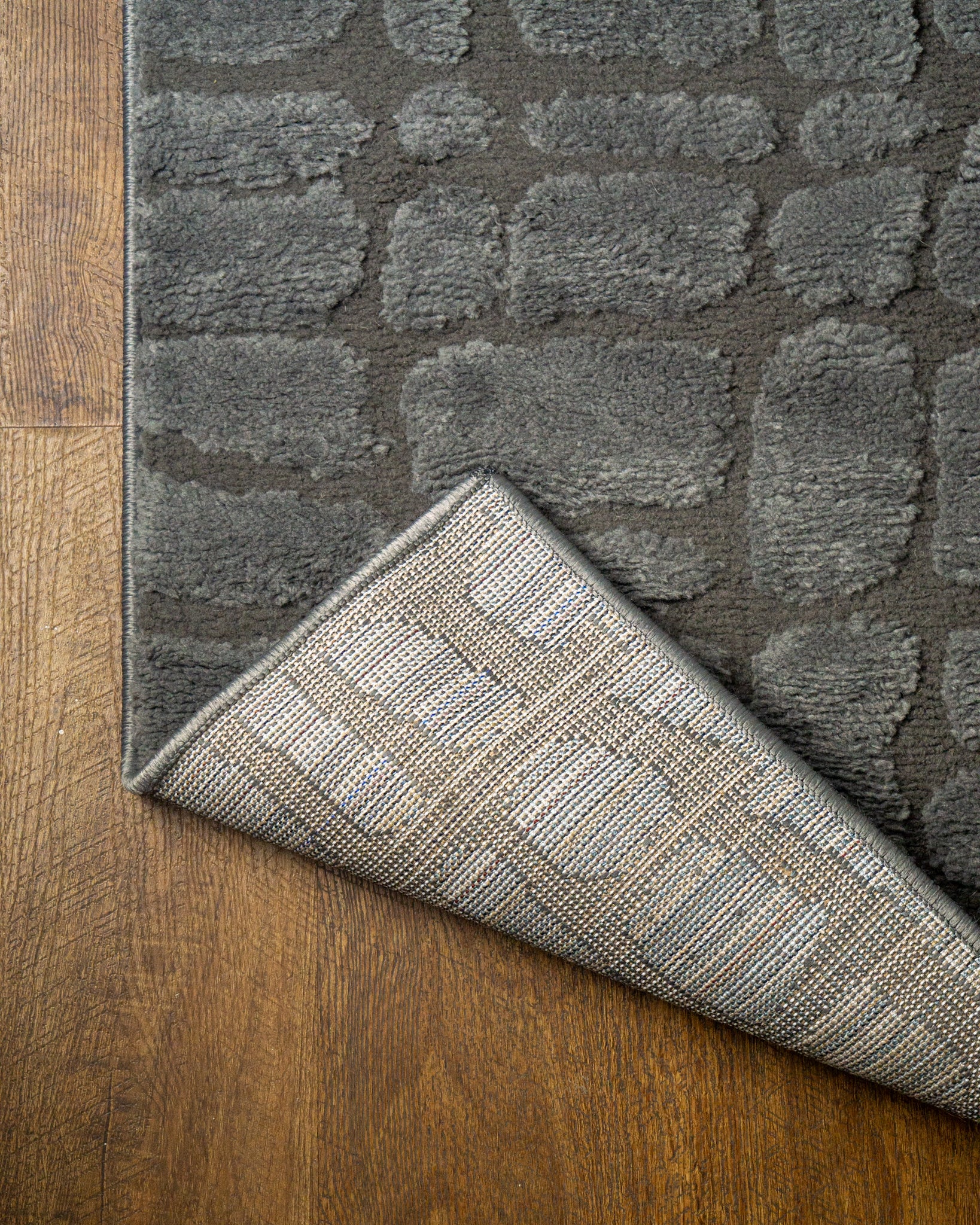 Grey crocodile textured area rug with geometric pattern in neutral tones