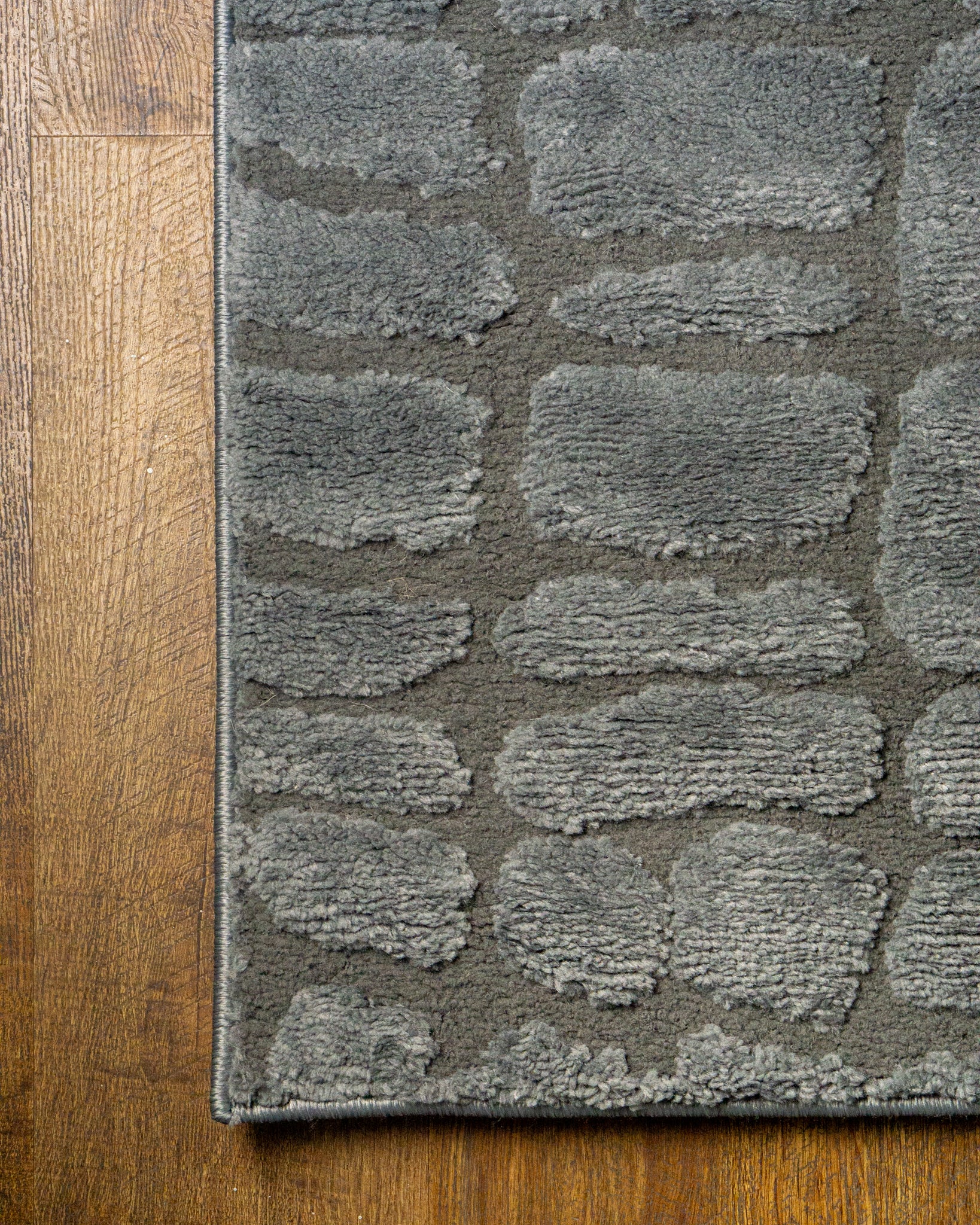 Grey crocodile textured area rug with geometric pattern in neutral tones
