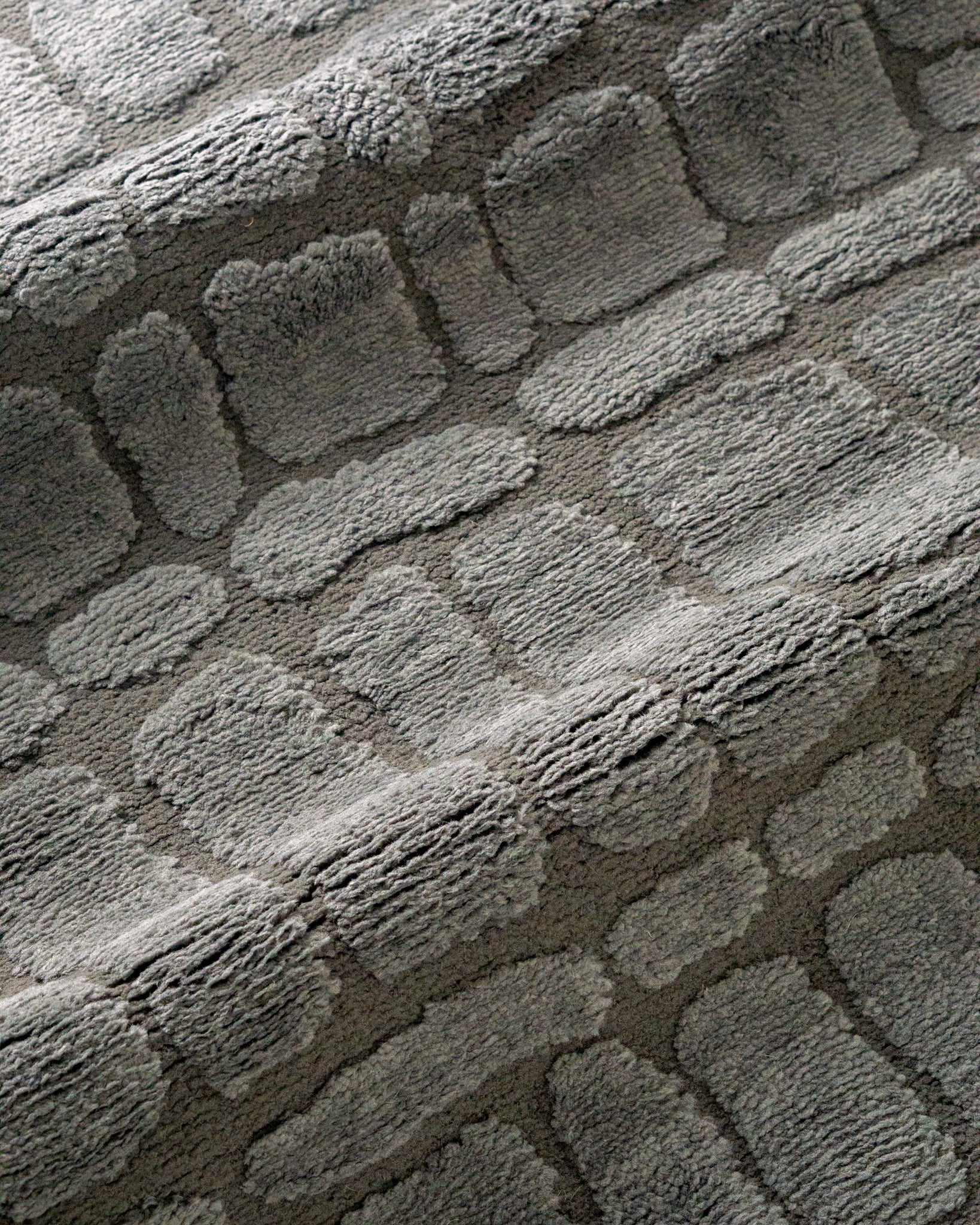 Grey crocodile textured area rug with geometric pattern in neutral tones