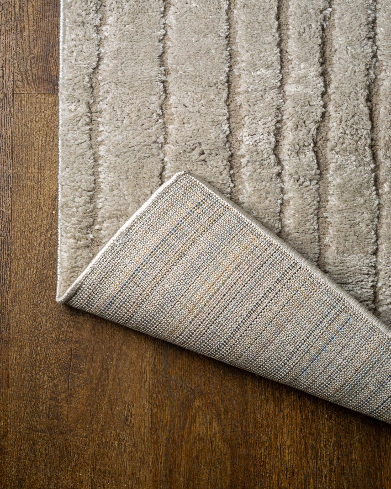 Beige geometric rug with concentric rectangles and vertical striped pattern