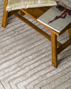 Beige geometric rug with concentric rectangles and vertical striped pattern