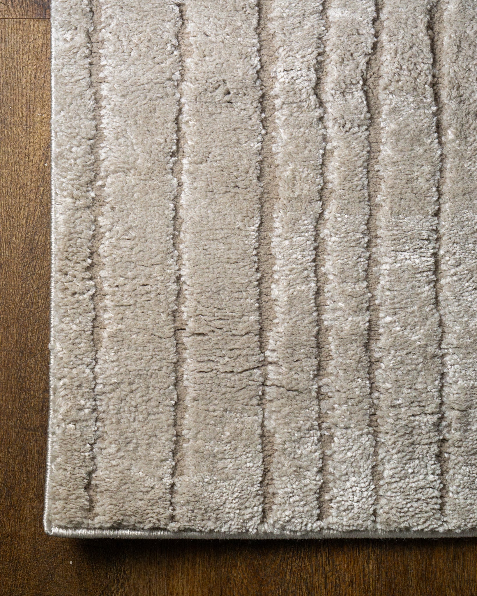 Beige geometric rug with concentric rectangles and vertical striped pattern