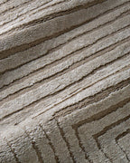 Beige geometric rug with concentric rectangles and vertical striped pattern