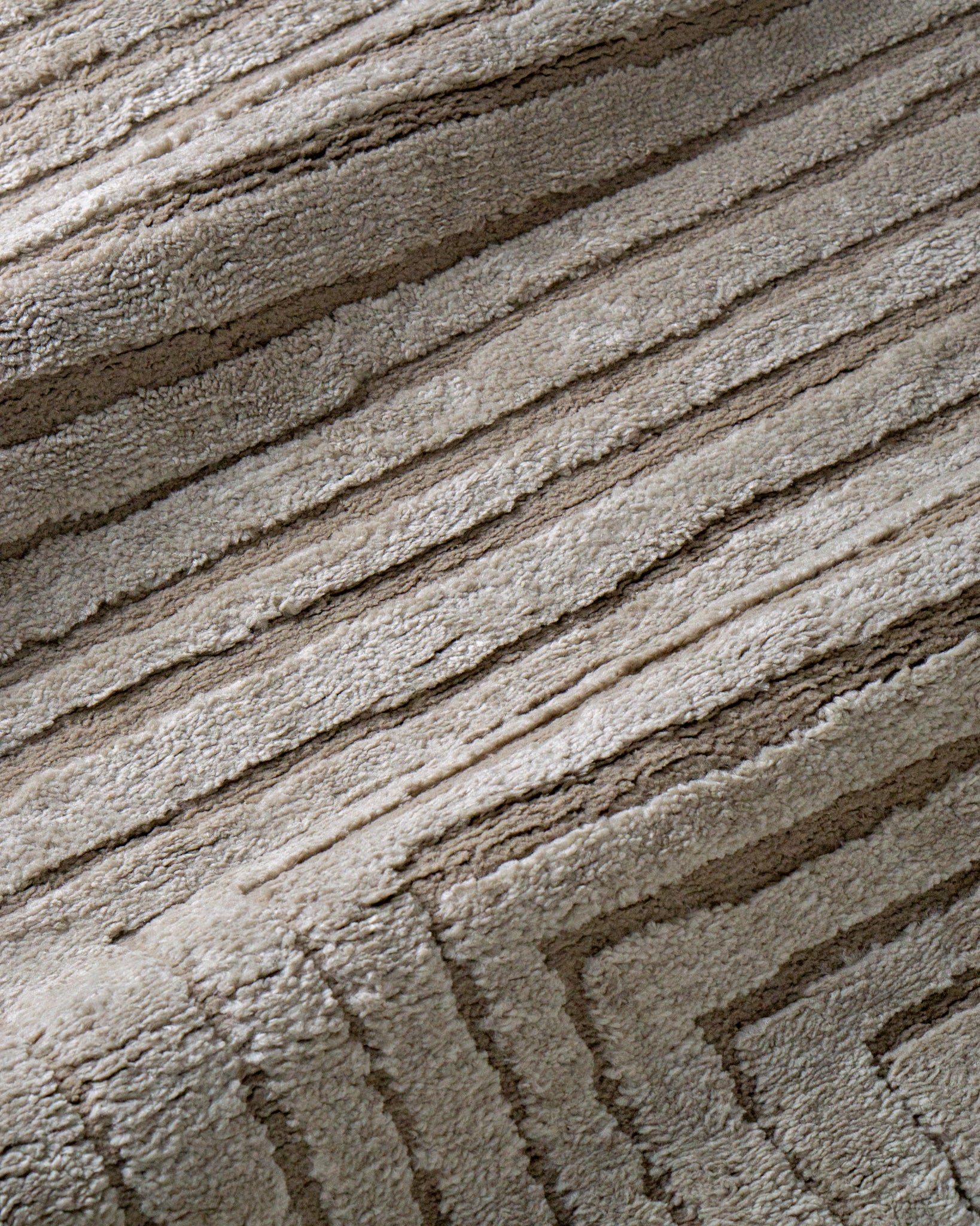 Beige geometric rug with concentric rectangles and vertical striped pattern
