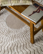 Beige and cream wavy geometric pattern rug with radiating sunburst design