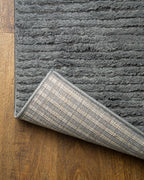 Grey textured area rug with horizontal woven pattern and neutral tone
