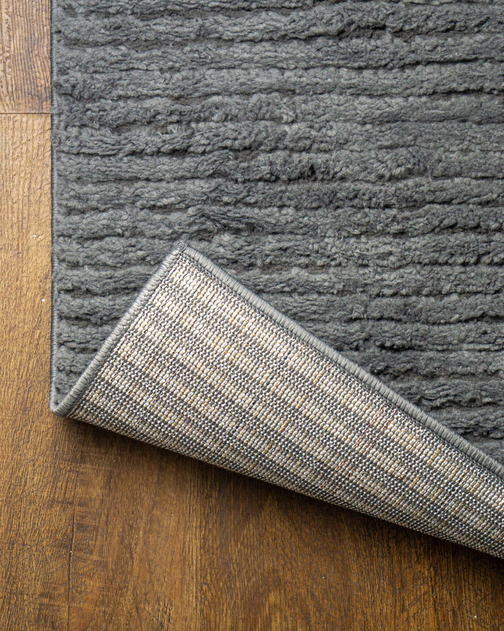Grey textured area rug with horizontal woven pattern and neutral tone
