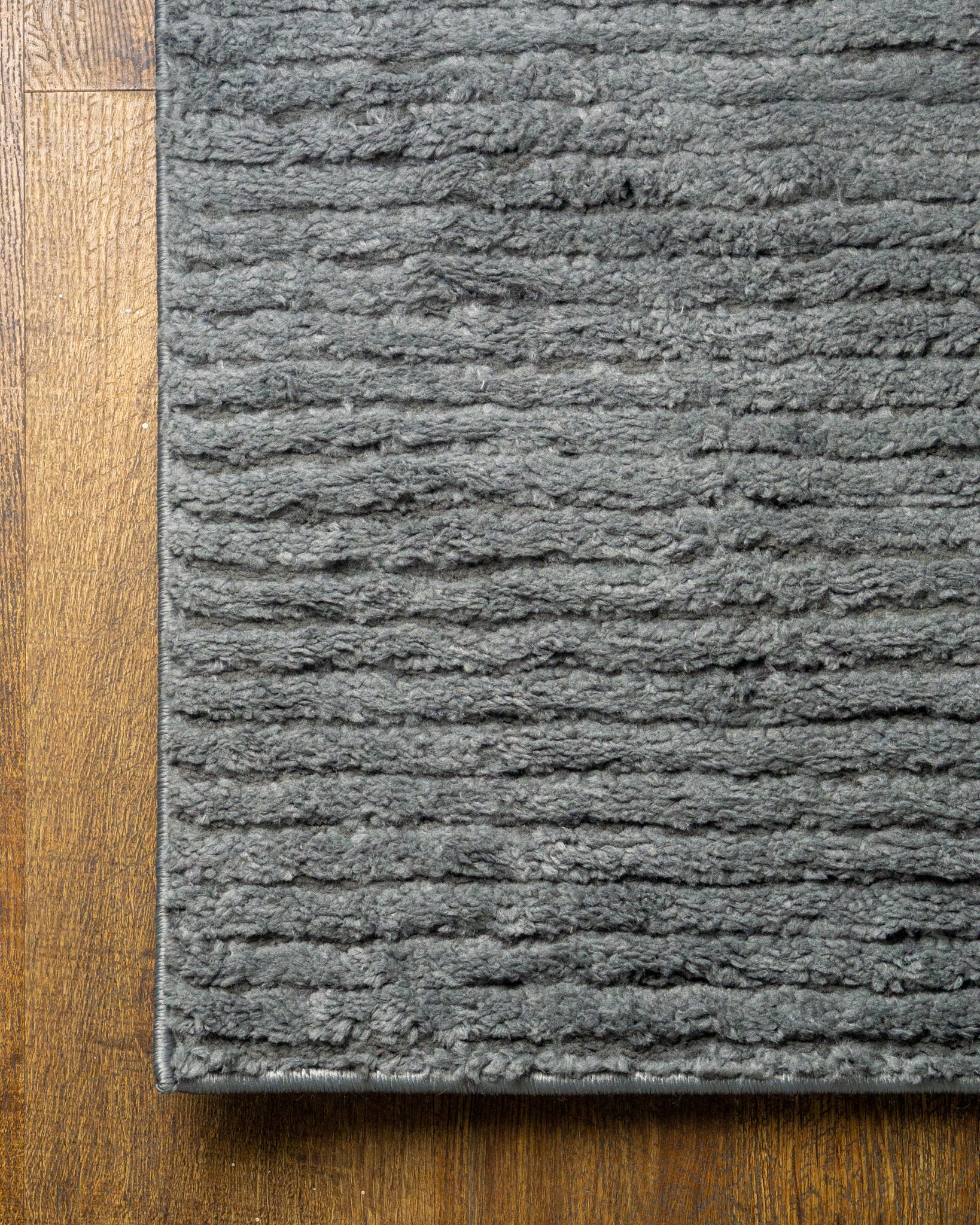 Grey textured area rug with horizontal woven pattern and neutral tone