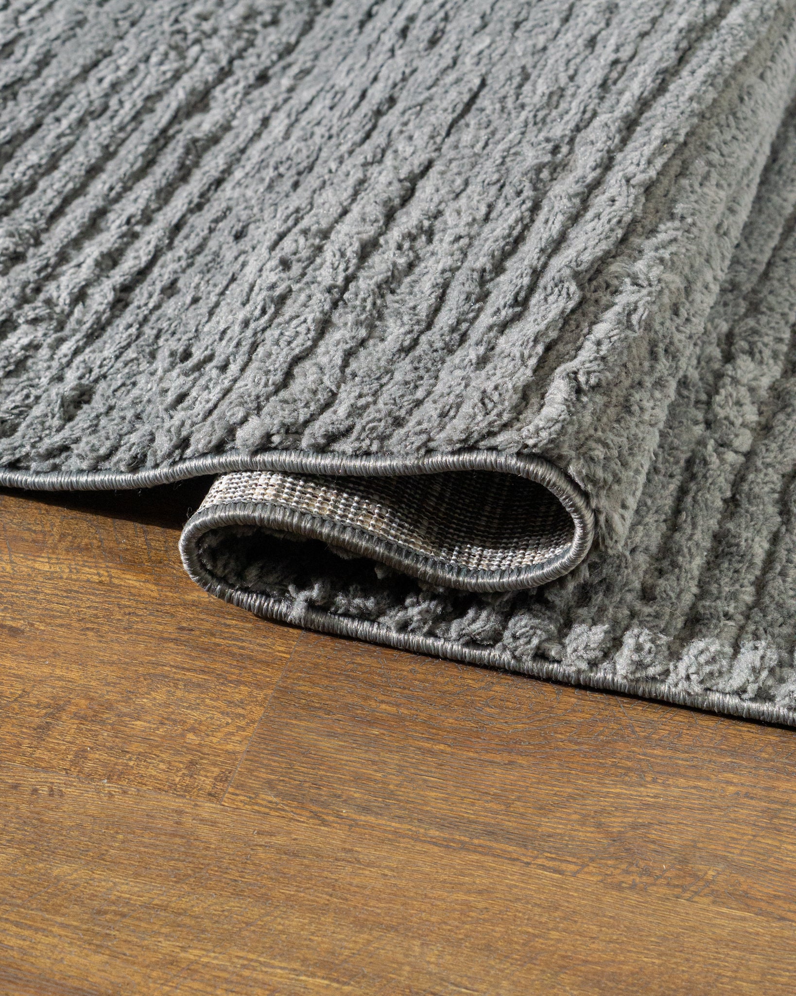 Grey textured area rug with horizontal woven pattern and neutral tone