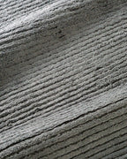 Grey textured area rug with horizontal woven pattern and neutral tone