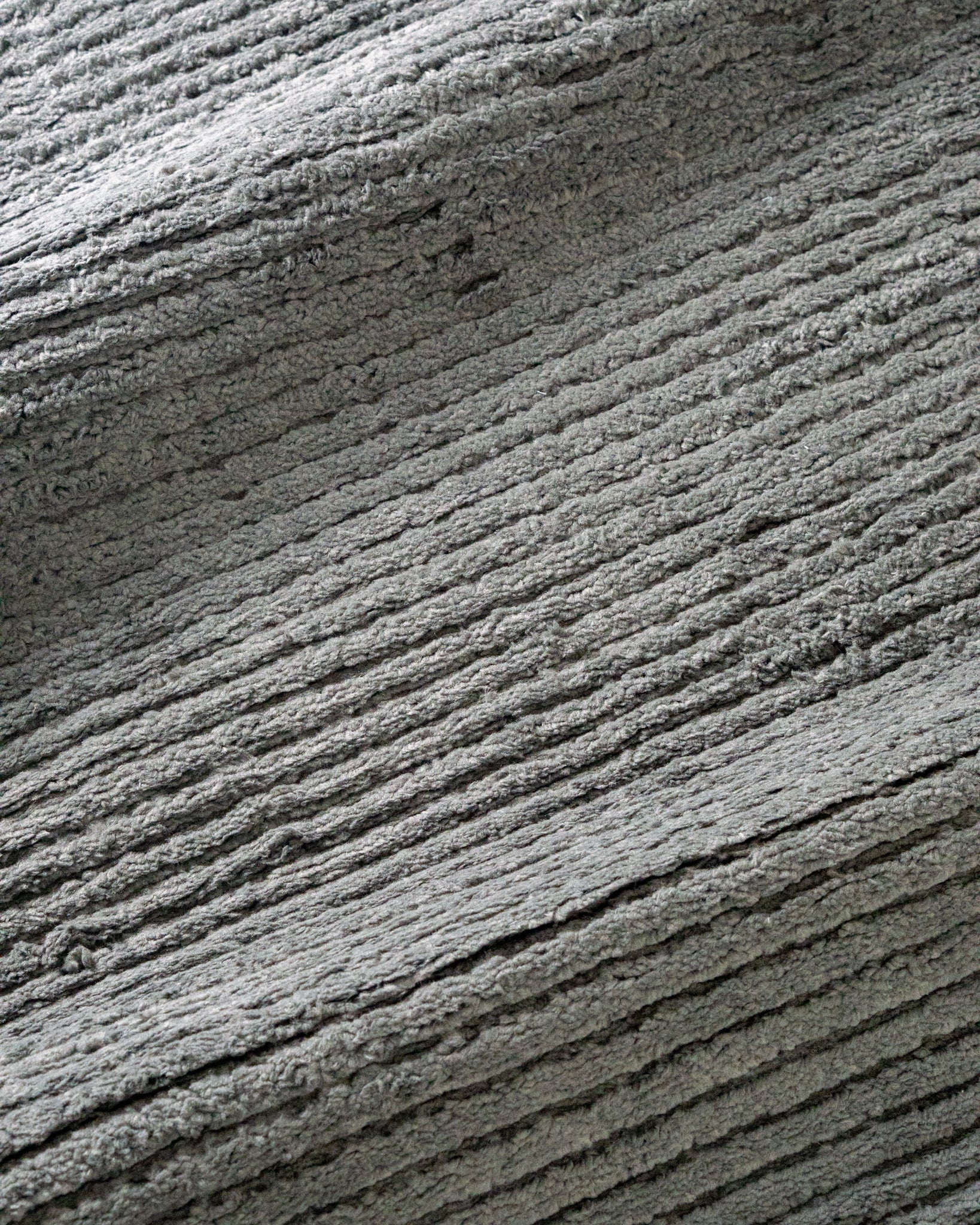 Grey textured area rug with horizontal woven pattern and neutral tone
