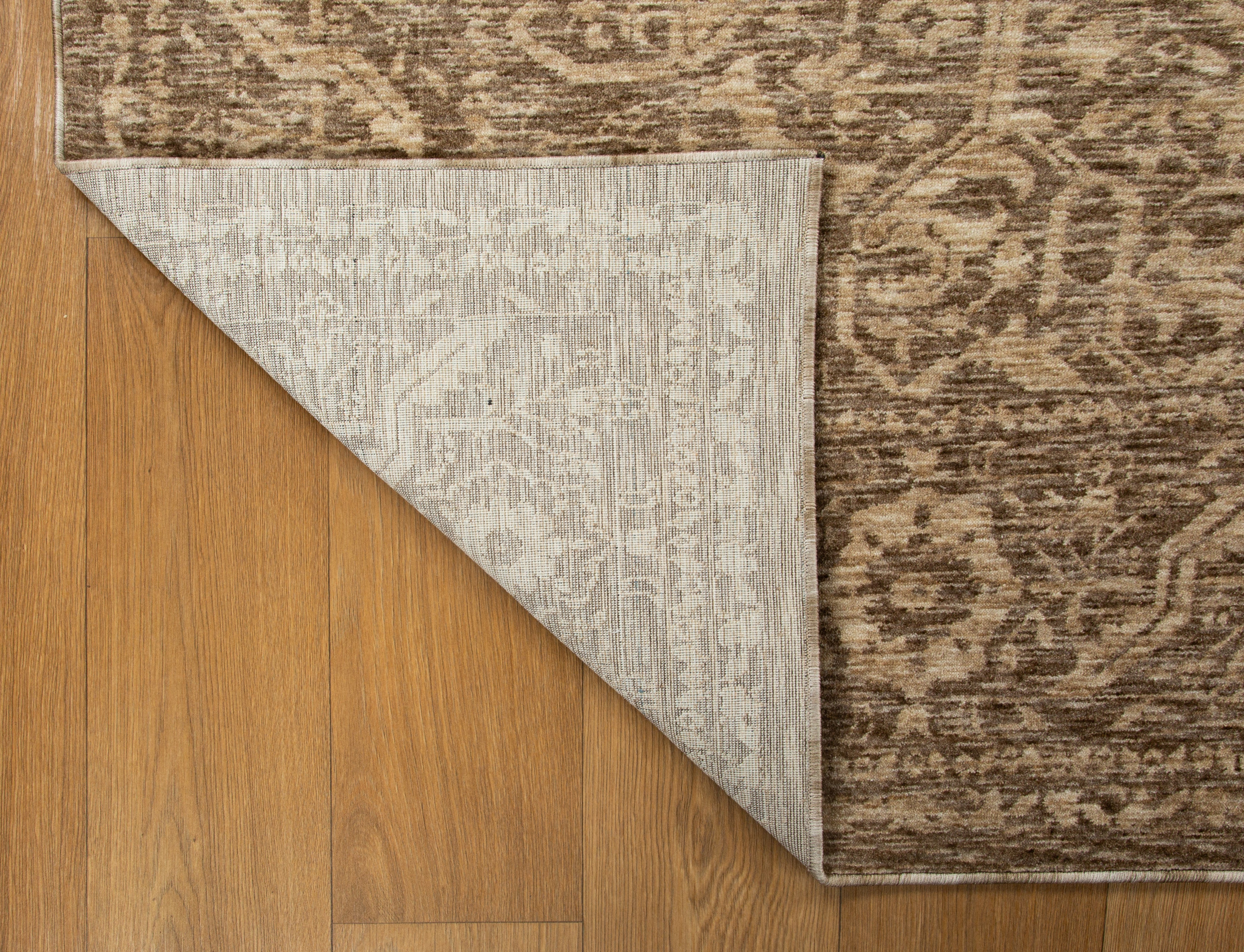 Taupe geometric damask patterned rug with textured woven appearance