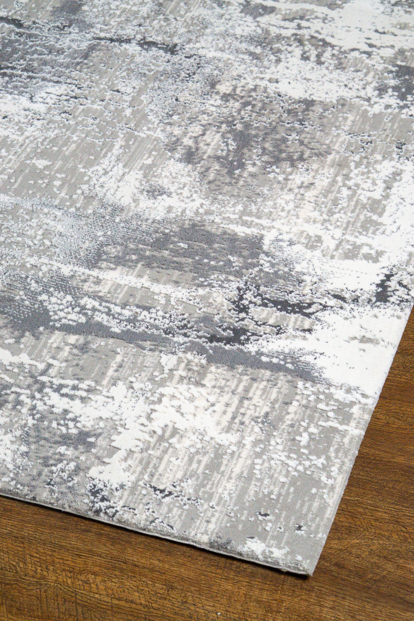 Distressed grey and white abstract area rug with weathered texture pattern