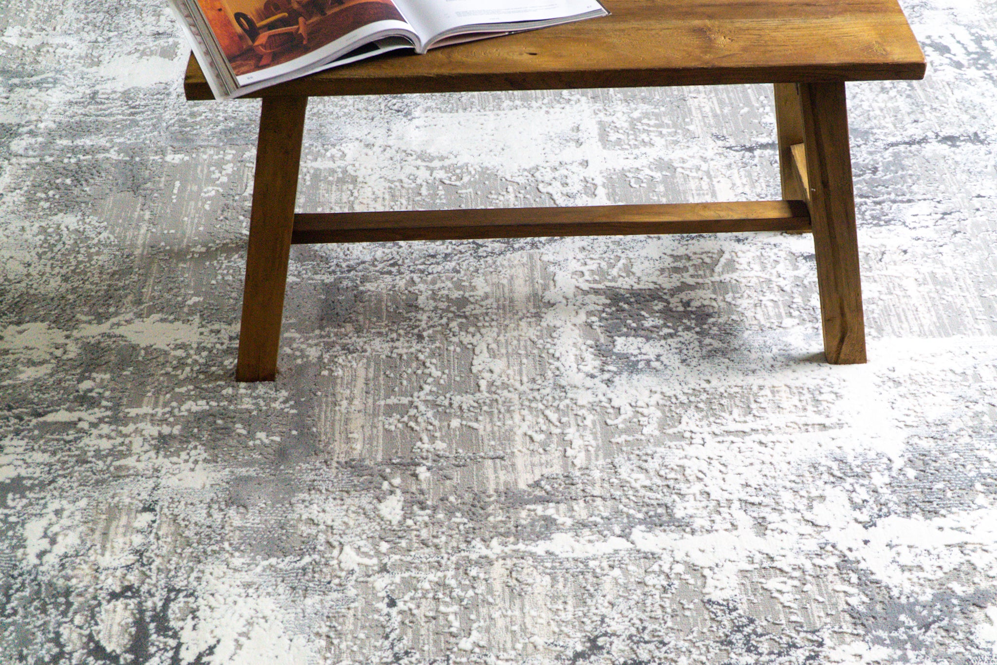 Distressed grey and white abstract area rug with weathered texture pattern