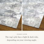 Distressed grey and white abstract area rug with weathered texture pattern