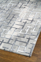 Modern geometric patterned rug in grey, white and blue tones with abstract design