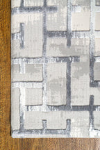 Modern geometric patterned rug in grey, white and blue tones with abstract design