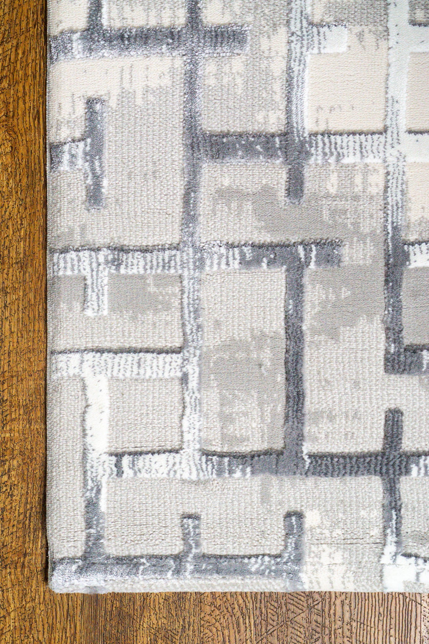 Modern geometric patterned rug in grey, white and blue tones with abstract design