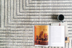 Modern geometric rug with nested square pattern in grey and cream tones