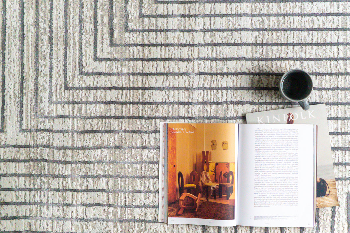 Modern geometric rug with nested square pattern in grey and cream tones