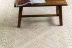 Geometric patterned rug in beige and cream with tribal diamond motifs